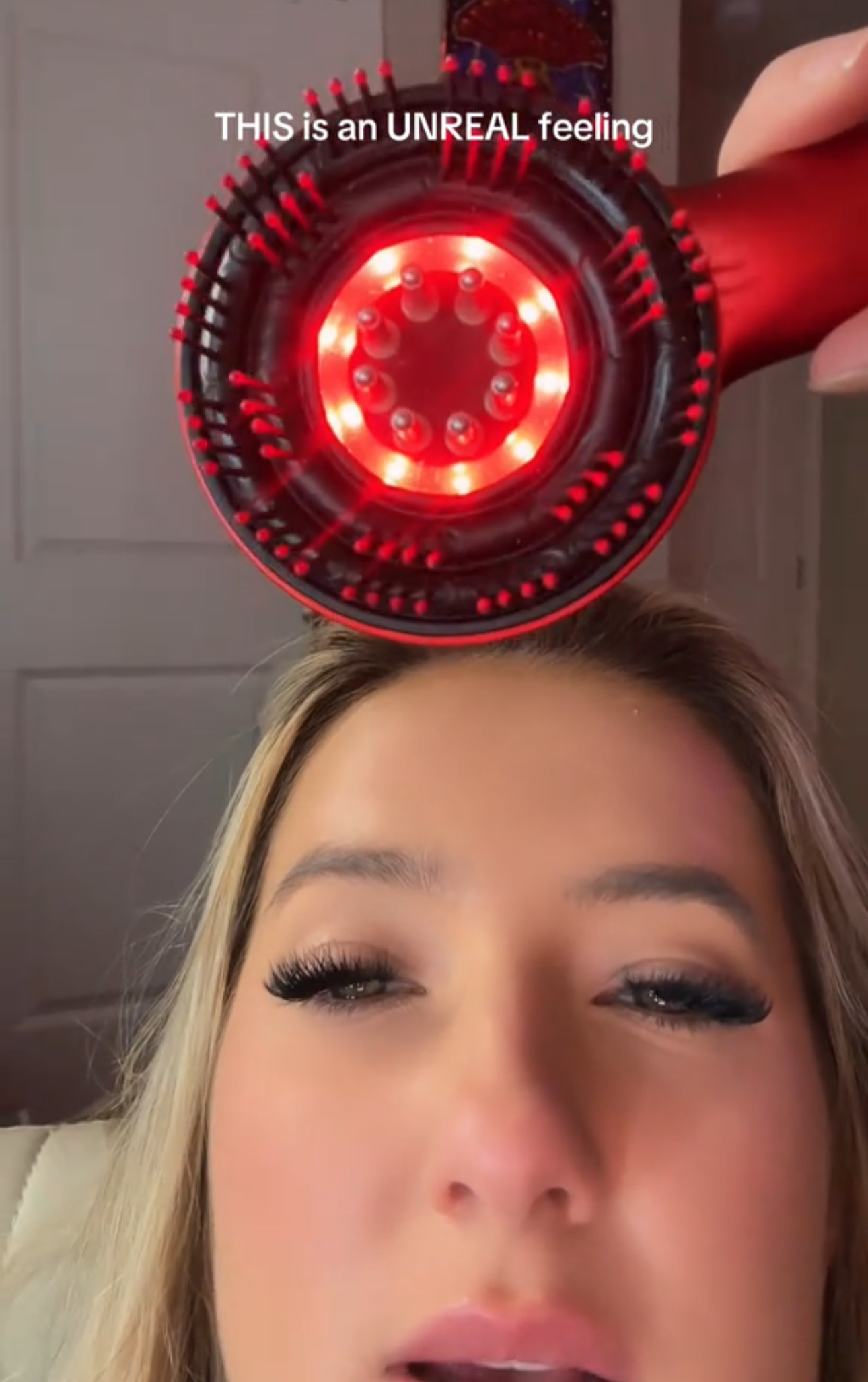 Person using a red hair dryer with text overlay 'THIS is an UNREAL Feeling' in a room.